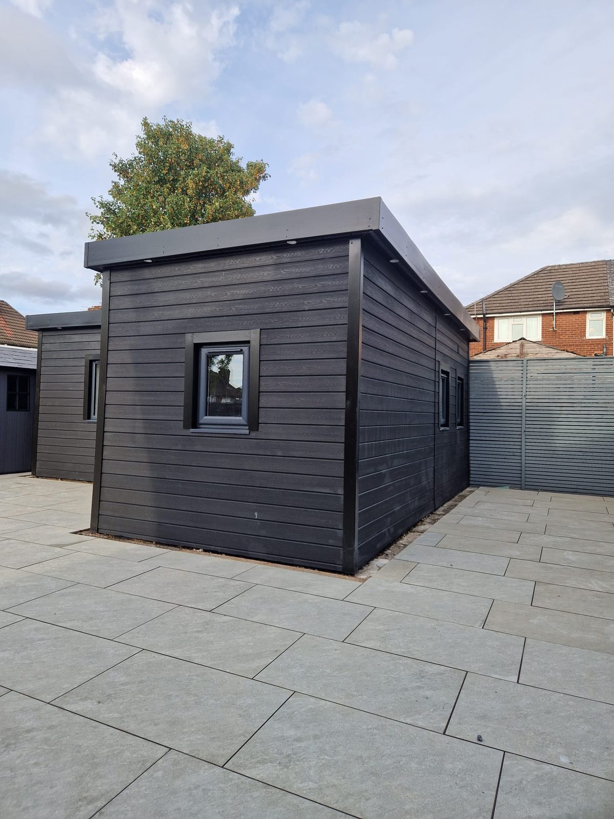 The garden room from the side, showing the cladding and flat roof