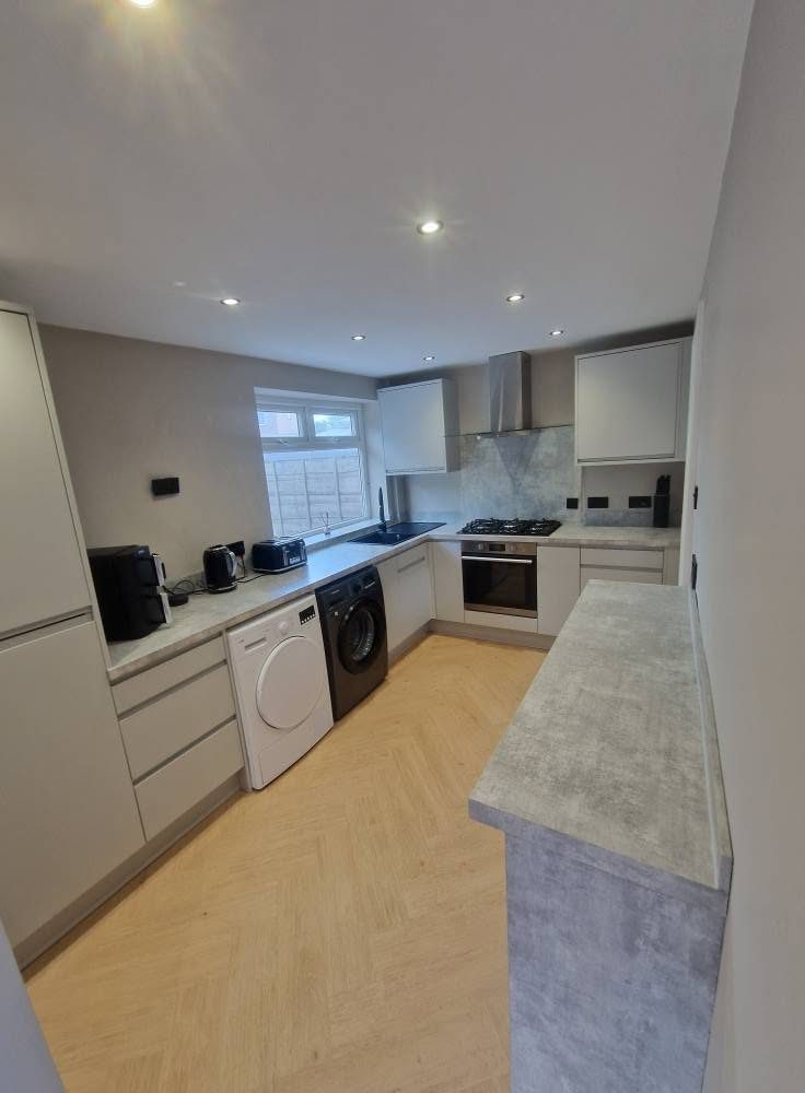 After: fitted kitchen with handleless units and herringbone flooring