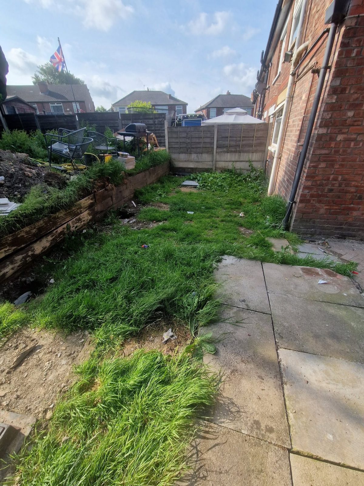 Before: overgrown garden with a rotten sleeper retaining wall